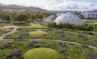 The countryside near Weil am Rhein, Germany, where the Vitra Campus is located. Visible is a dome by Buckminster Fuller among greenery and purple flowers, part of Piet Oudolf's garden design