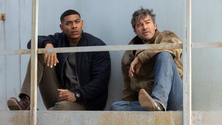 Aaron Pierre and Kyle Chandler sitting down together in Lanterns
