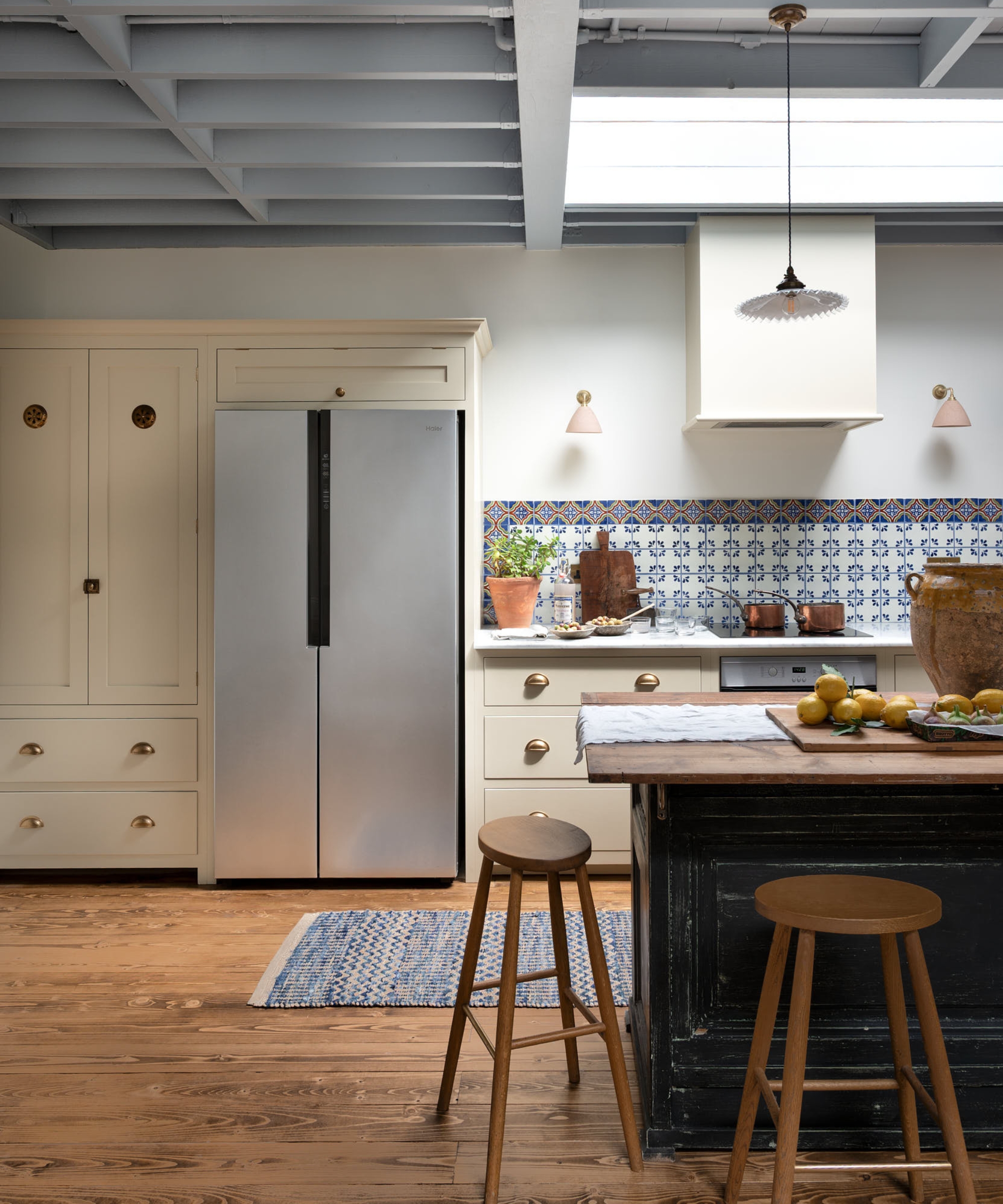 A cream and blue kitchen with a stainless steel fridge/freezer