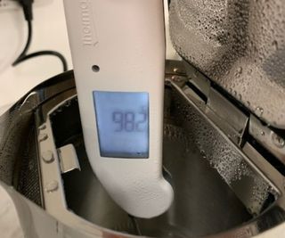 A thermometer measuring the temperature of the water inside the Aarke Kettle.