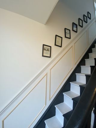 Mid-way through painted half black and white staircase with wall art