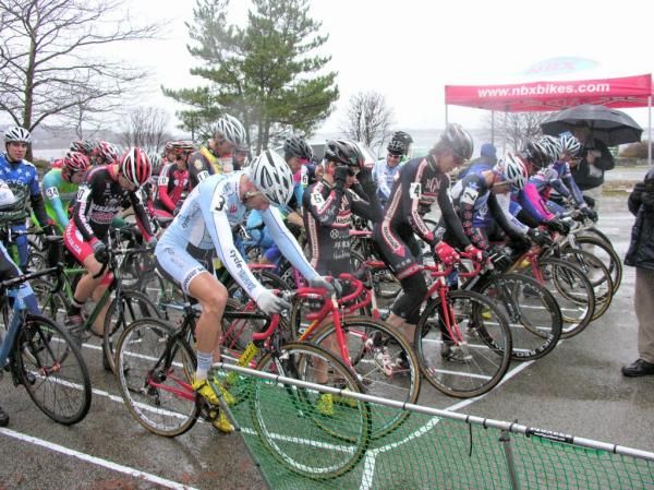 The elite men try to keep warm in the cold rain.