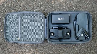 The carry case laid open with the drone, controller, and accessories box stored inside.
