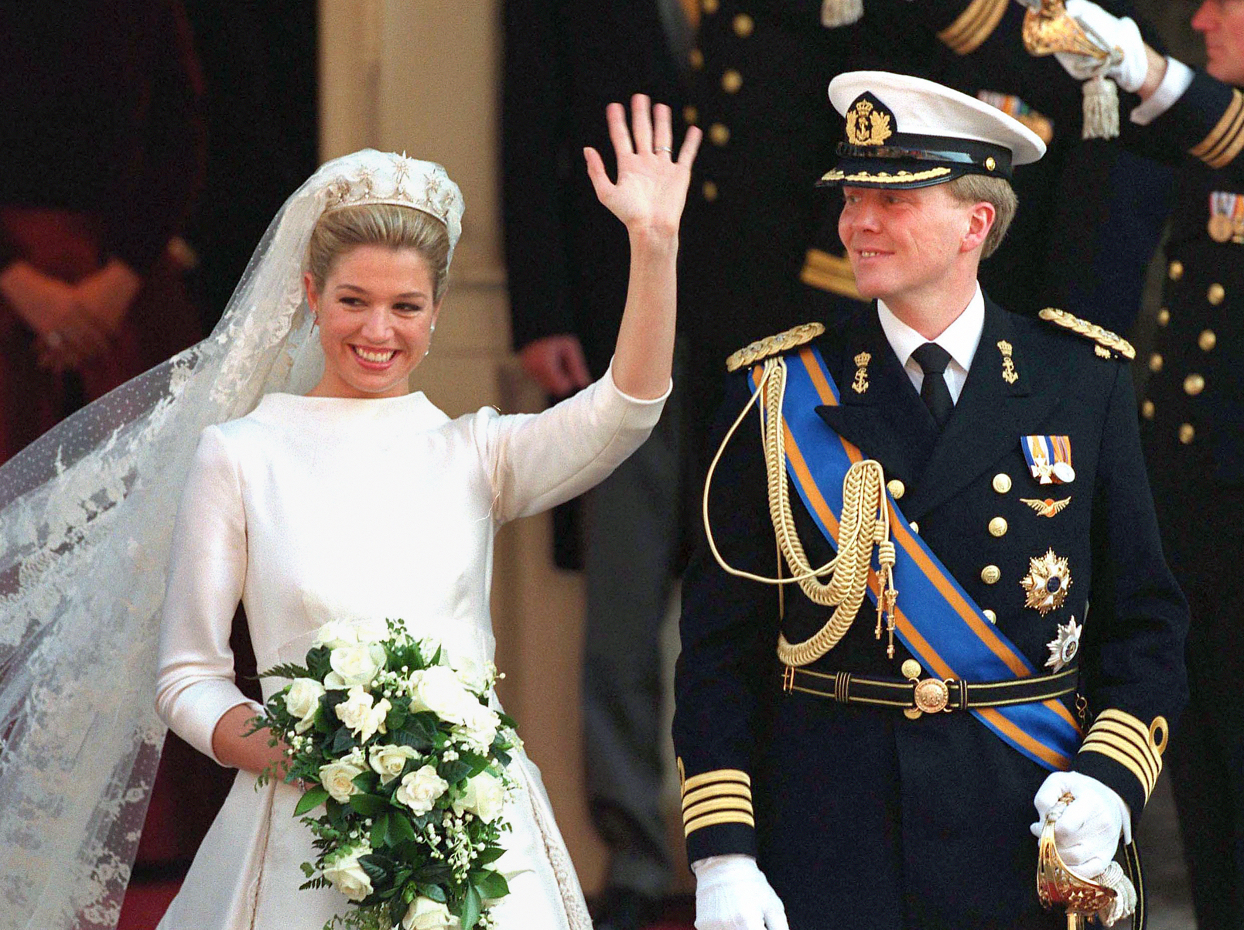 Queen Maxima waving on her wedding day standing next to King Willem Alexander