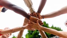 Several volunteers join hands as a team.