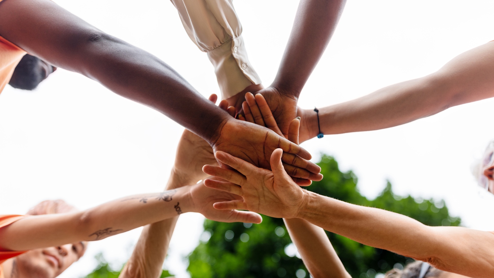 Several volunteers join hands as a team.