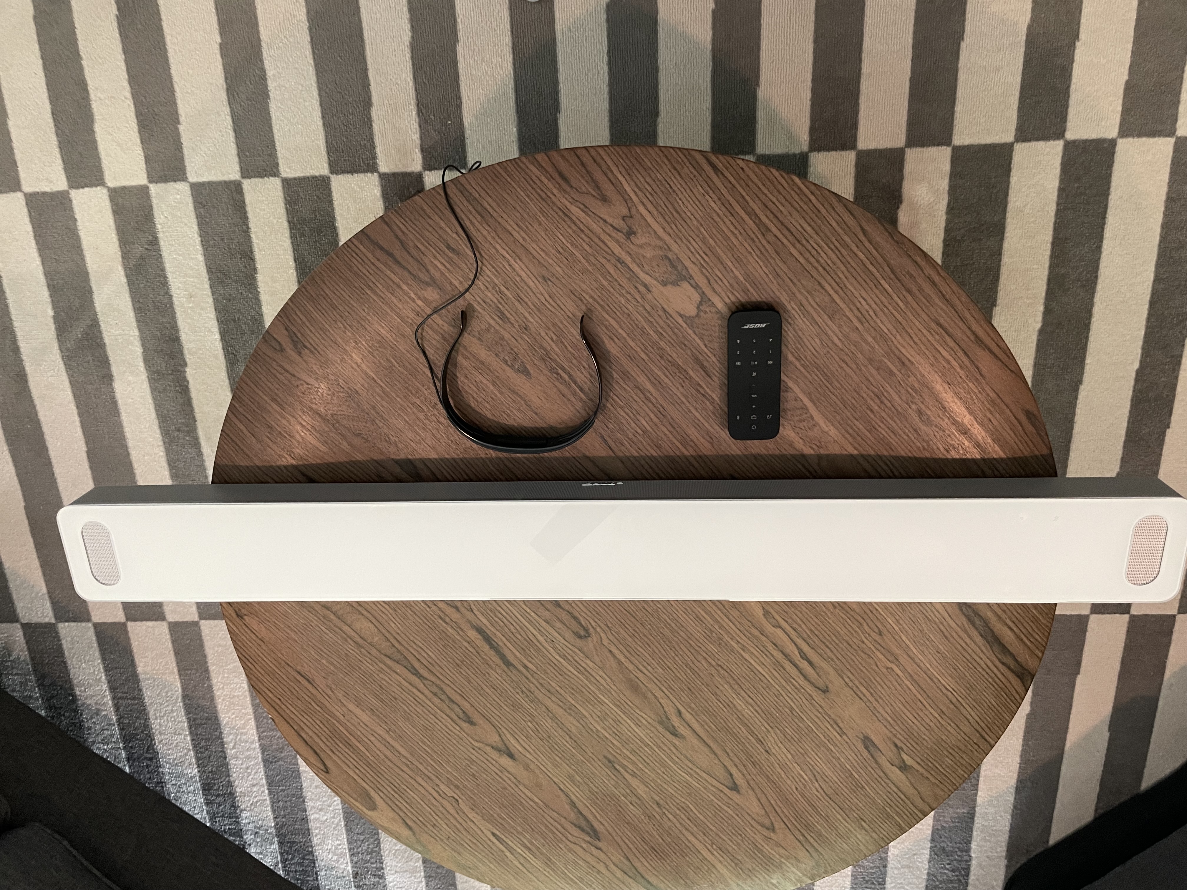 Bose Smart Soundbar 900 and accessories placed on wooden table top