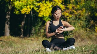 Frau beim Yoga mit Fitness-Tracker