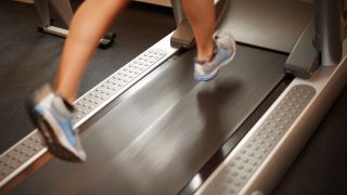Close-up of runner’s feet moving at speed on treadmill belt