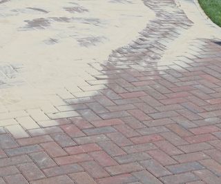 Spreading sand over block paving to fill gaps