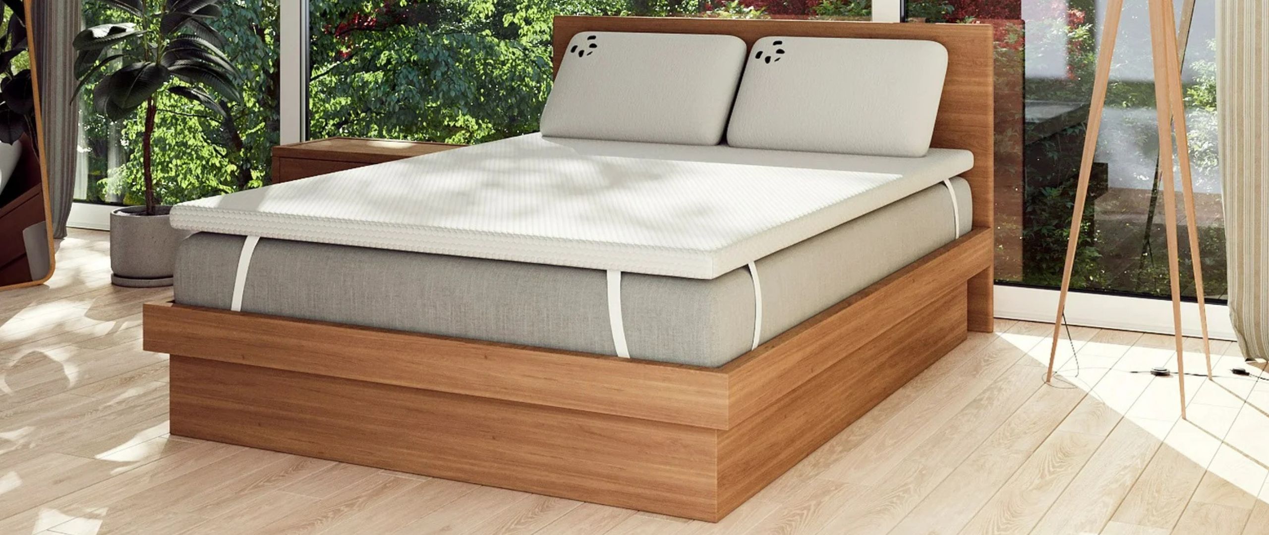 The Panda Bamboo 2&quot; Memory Foam Mattress Topper on a grey mattress in a bright, modern bedroom overlooking a green garden.