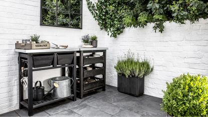 Potting bench on a courtyard patio with a garden mirror on one wall