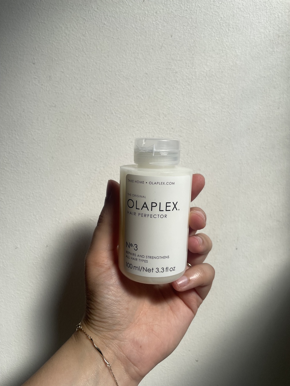 Mica Ricketts holding bottle of Olaplex No.3