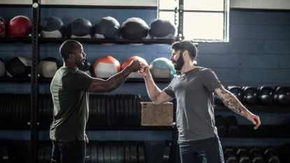Two friends fist bumping in a gym about to start a workout