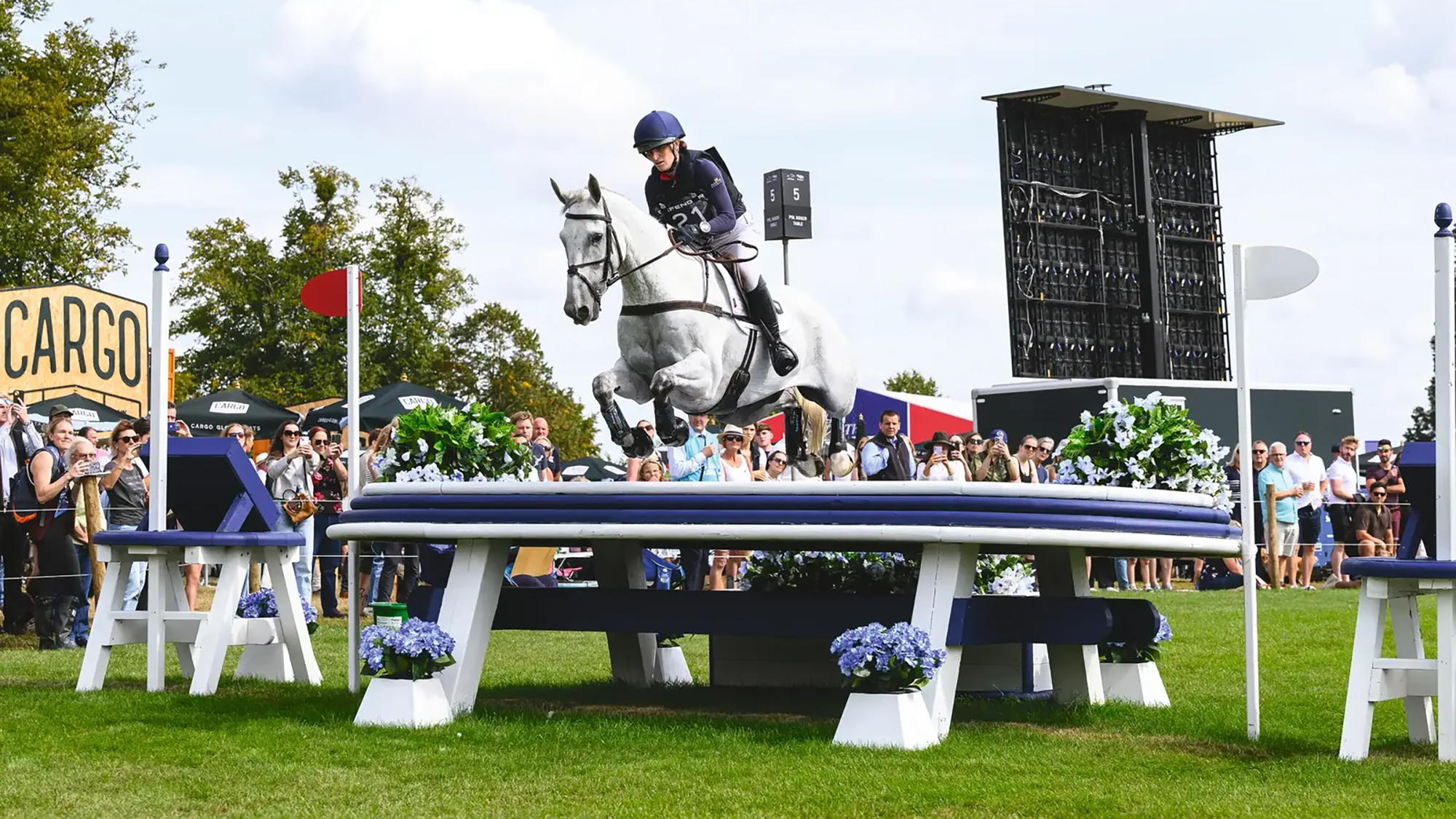 Holly Richardson and Ballyneety Silver Service clear a large white and blue table on the Defender Burghley Horse Trials 2025 cross-country course