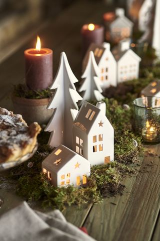 Christmas table with tea light houses, moss and foliage garland