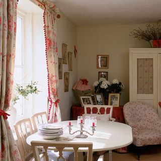 dinning room with cream colour wall white dinning table with chairs frames on wall