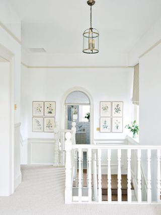 traditional-style landing and staircase with flower prints and view to bathroom