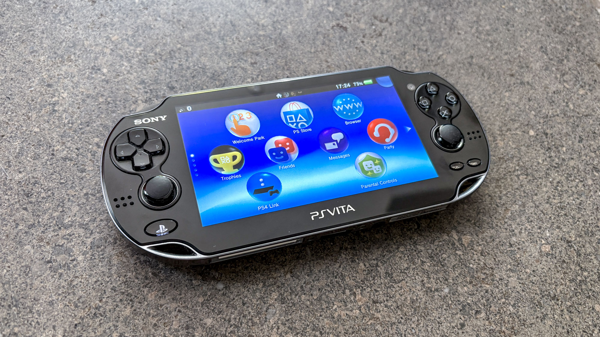 PS Vita on surface with homescreen menu on display
