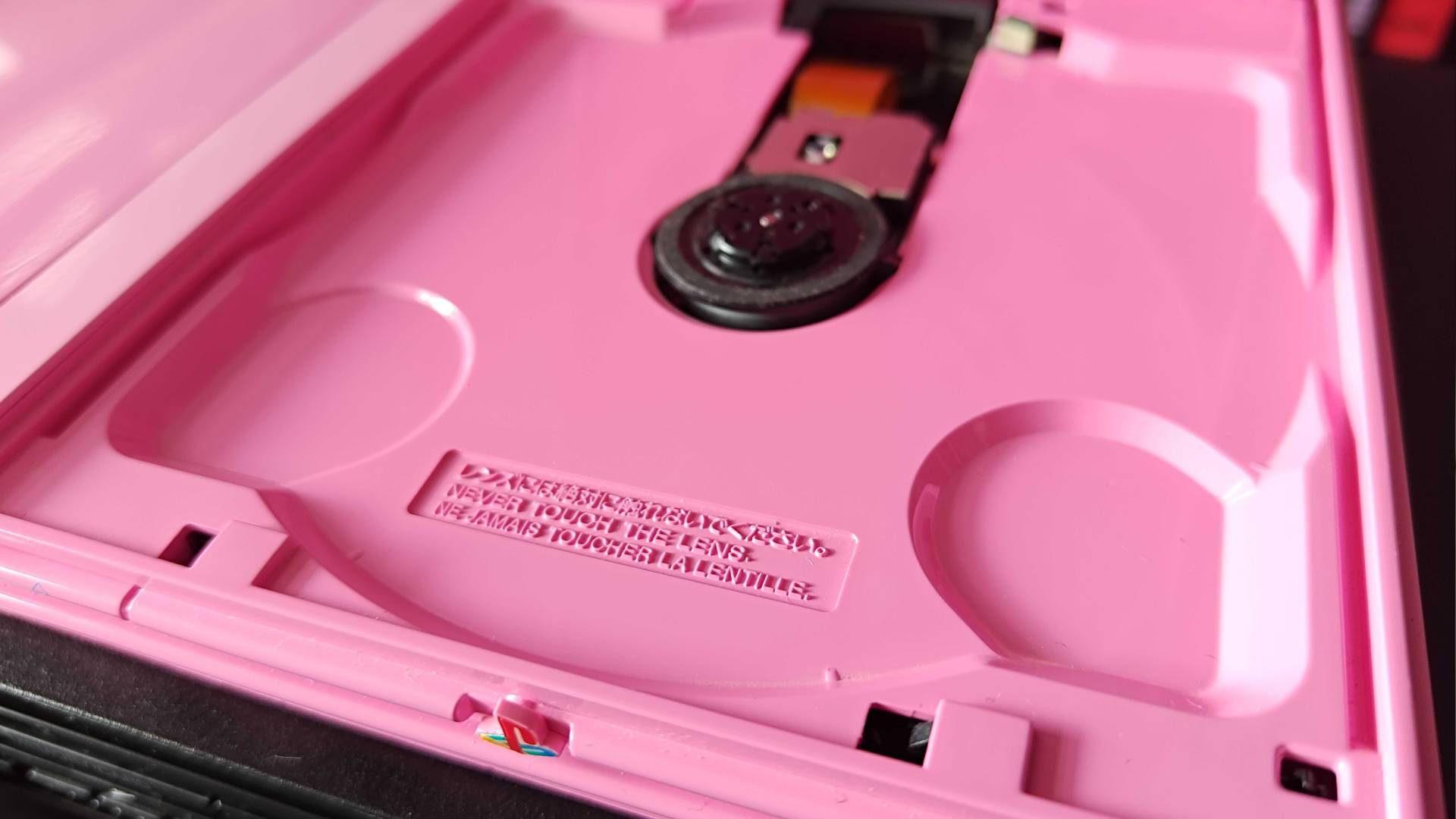 Close up of pink PS2 Slim disc tray and lens.