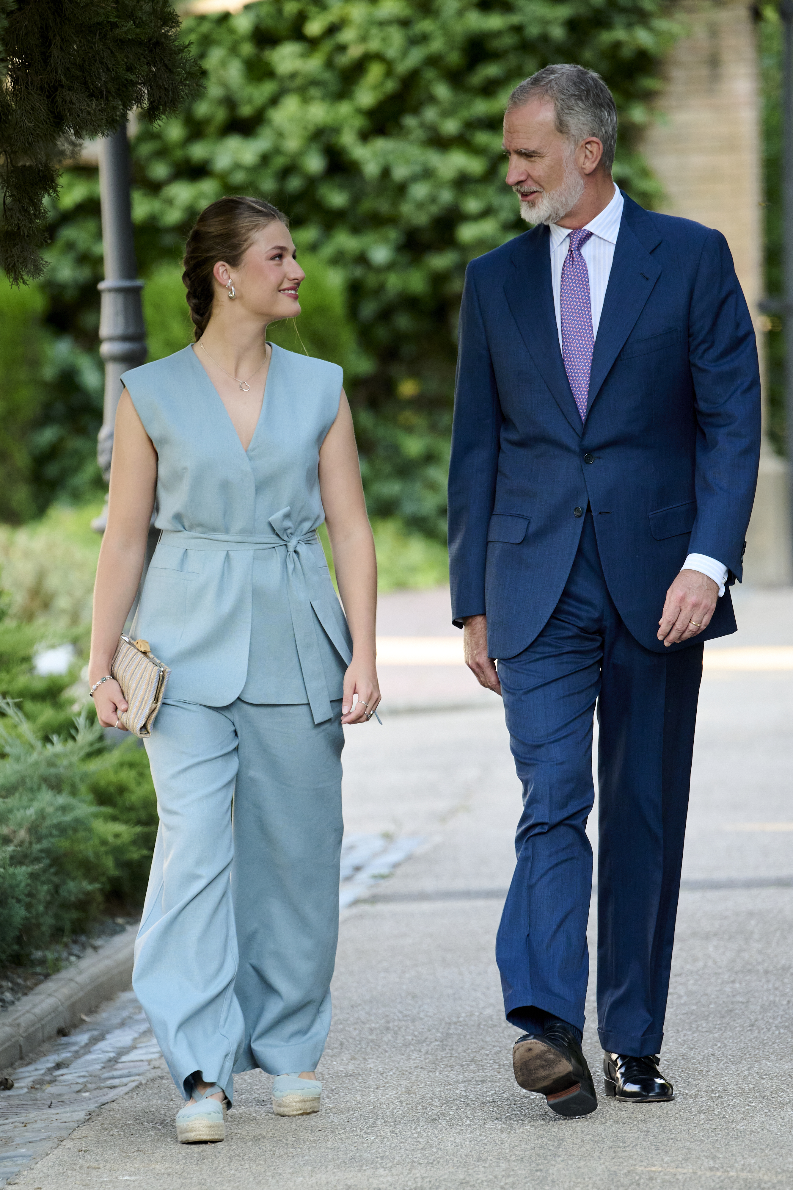 Princess Leonor wears a blue suit and smiles at King Felipe