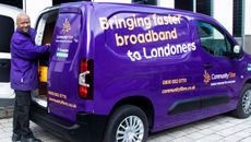 A Community Fibre employee stands next to the company van with the slogan "Bringing faster broadband to Londoners"