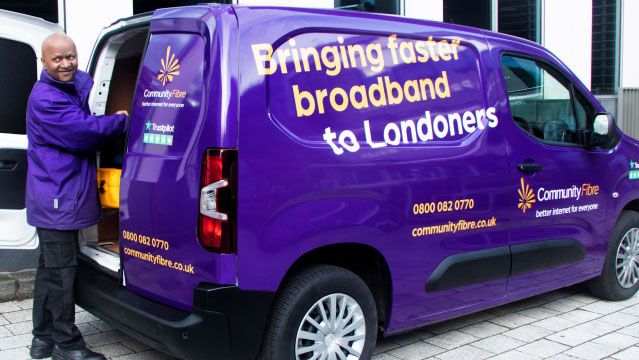 A Community Fibre employee stands next to the company van with the slogan &amp;quot;Bringing faster broadband to Londoners&amp;quot;