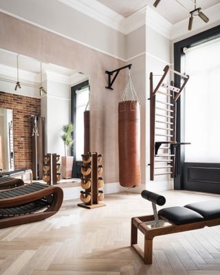 a home gym with a bench on one side, treadmill and weights on a rack.