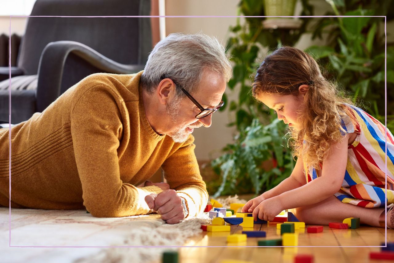 Grandfather playing on the floor with his granddaughter 