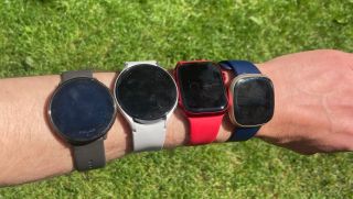 Four fitness trackers on an arm