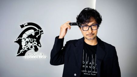 Hideo Kojima holds the Death Stranding harmonica to his head