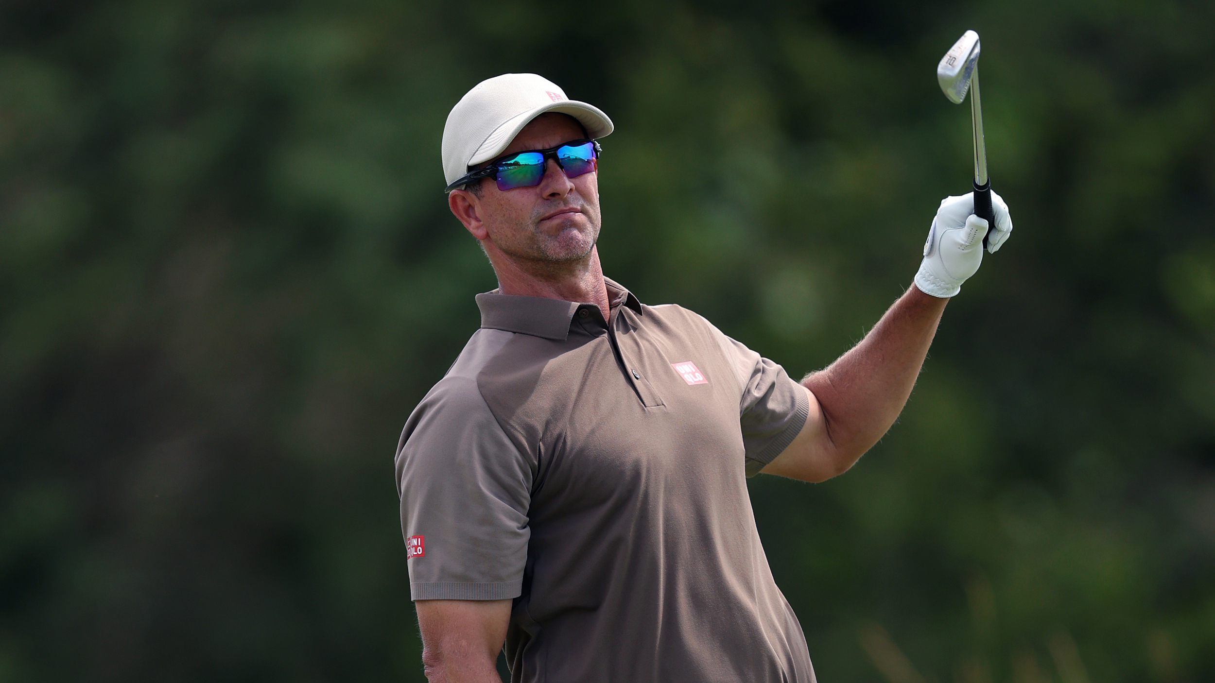 Adam Scott takes a hand off an iron shot