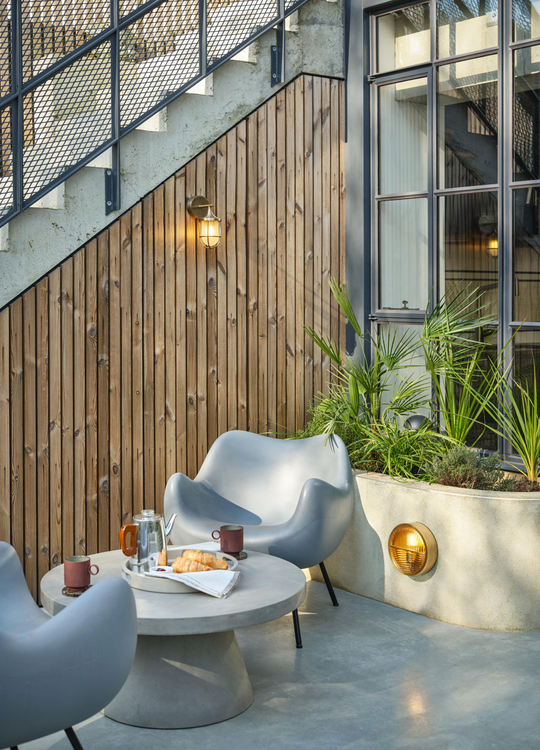 small modern patio with industrial style lighting and silver outdoor chairs