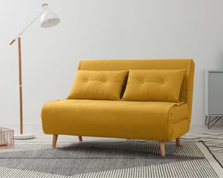 A yellow fabric sofa bed in a modern living room