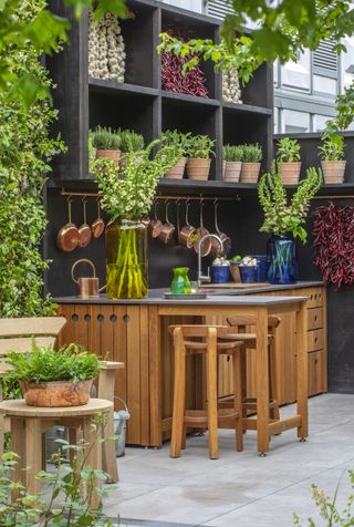 a one wall outdoor kitchen with a small peninsula for seating