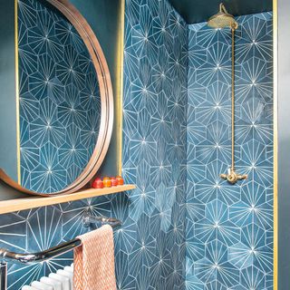 bathroom with blue designed wall shower mirror and towel rail