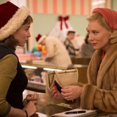 rooney mara as therese in a santa hat and cate blanchett as carol shopping at the department store counter in the movie carol