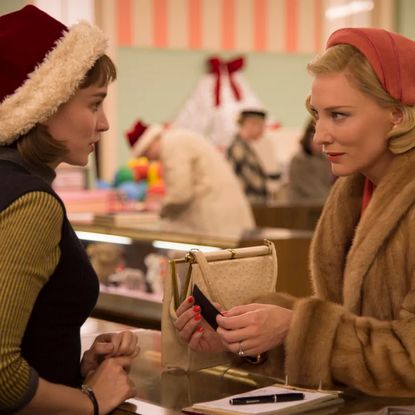 rooney mara as therese in a santa hat and cate blanchett as carol shopping at the department store counter in the movie carol