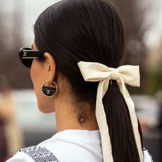 Fashion week attendee wearing a Chanel bow in her hair