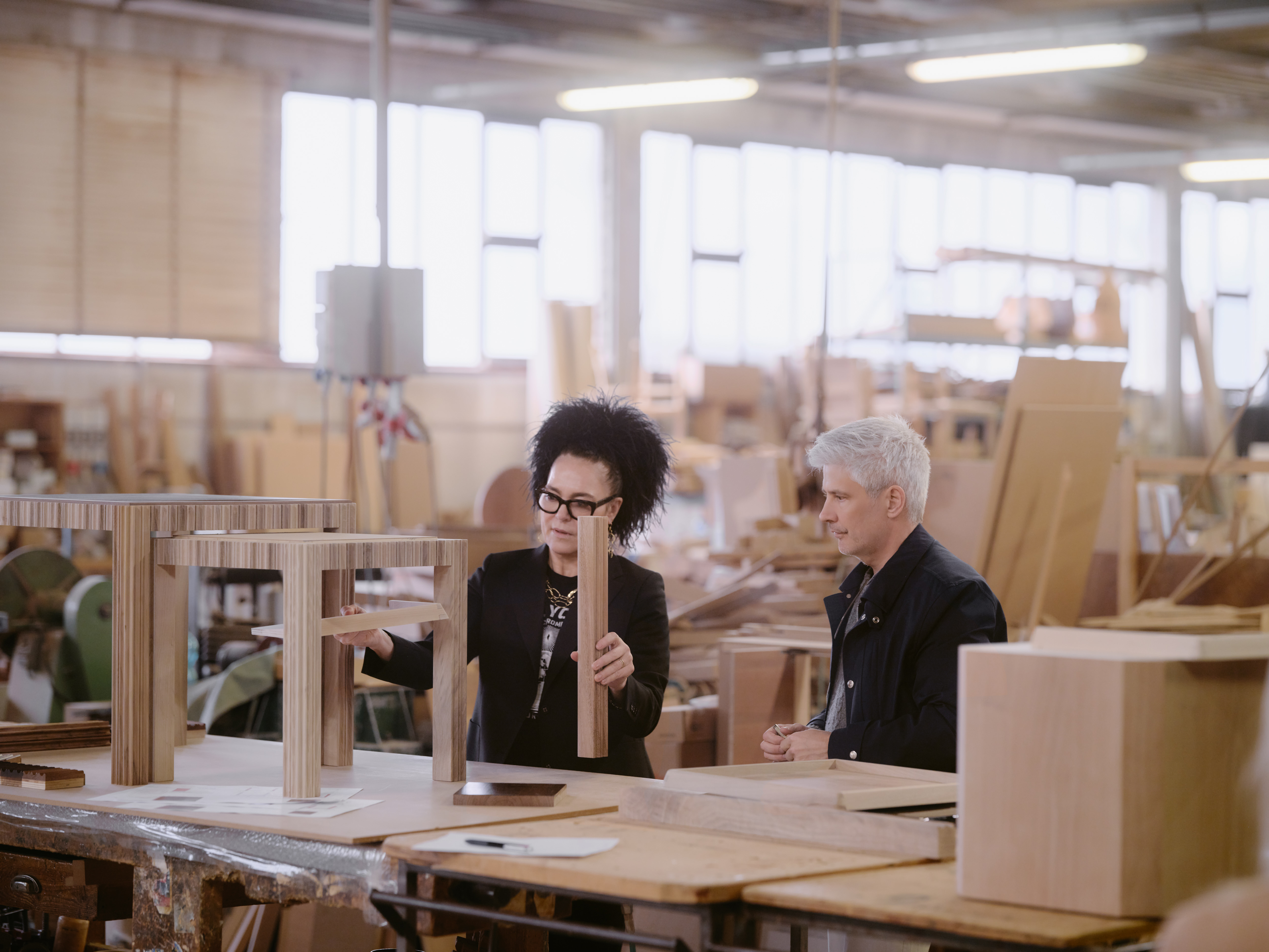 Behind-the-scene shots documenting the project phase and manual elaboration of different artisanal pieces of furniture, set inside a workshop and depicting designers dressed in casual-chic clothing.