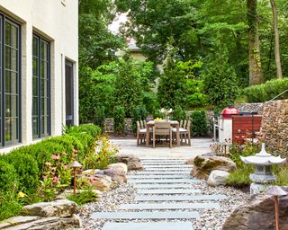 Backyard landscaping ideas showing a walkway of Pennsylvania bluestone pavers surrounded by Delaware river stone