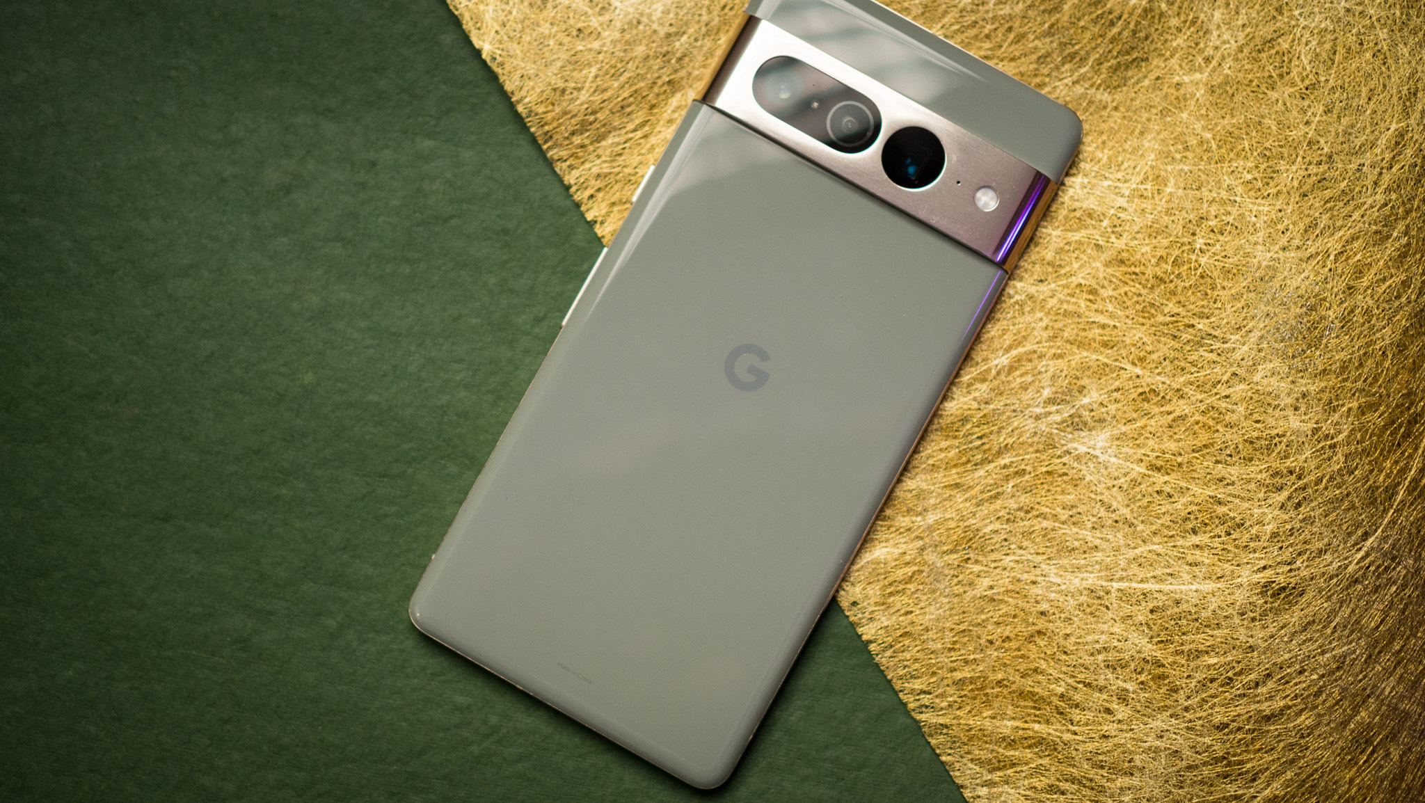 Google Pixel 7 Pro back view with Google logo highlighted against green and gold background