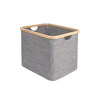 A grey fabric laundry hamper with a wooden bamboo trim around the top