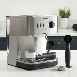 Silver Breville Espresso Coffee Machine on a white kitchen counter-top