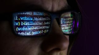 Computer code reflected in glasses arranged in Danbury, U.K., on Wednesday, Dec. 30, 2020. In the spring, hackers managed to insert malicious code into a software product from an IT provider called SolarWinds Corp., whose client list includes 300,000 institutions. Photographer: Chris Ratcliffe/Bloomberg via Getty Images