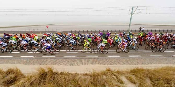 The peloton rides along a notably calm North Sea coast early on during Gent-Wevelgem