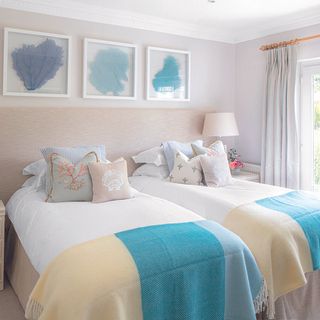 guest room with teal wall and white bedside lamp and curtain