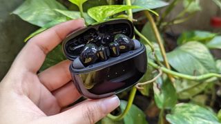 UGREEN HiTune T3 ANC earbuds inside case with lid open held in one hand