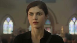 A close up of Alexandra Daddario wearing red lipstick and looking forward with a serious expression on Mayfair Witches.