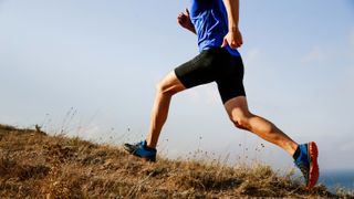 the lower half of a man running up a hill